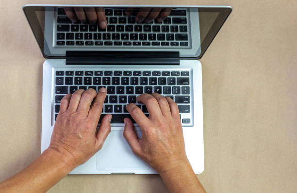 istock male hands on laptop isolated on khaki background 1225886091