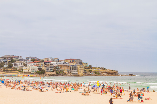People relaxing in summer season in a cloudy day after New Year's eve in Bondi beach Sydney, Australia.