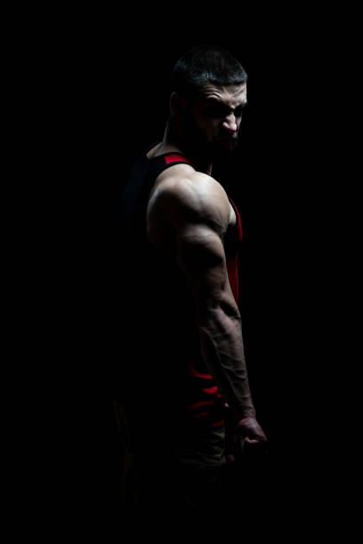 istock Muscular Man Flexing Muscles on Black Background 1225892673