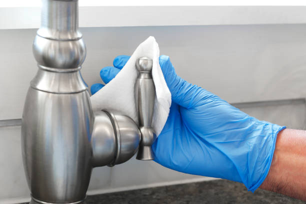 istock Man Wearing Protective Glove Cleans Faucet Handle With Disinfectant Wipe 1225897773