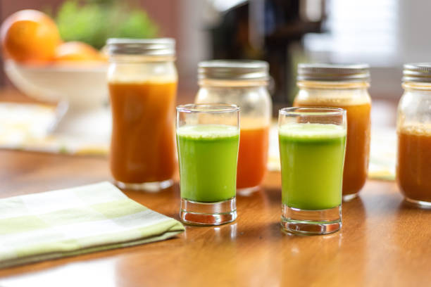 closeup de copos de suco de aipo nutritivo fresco na mesa da cozinha - cold pressed - fotografias e filmes do acervo