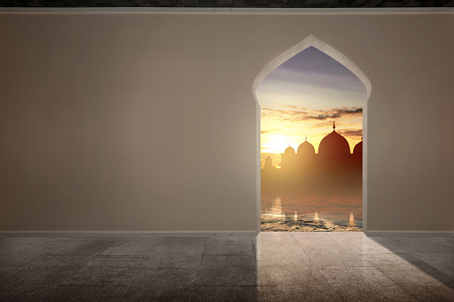 The arch on the wall with mosque view and sunset sky background