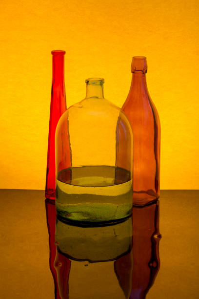 istock Still life with colored glassware on a yellow background 1225907790