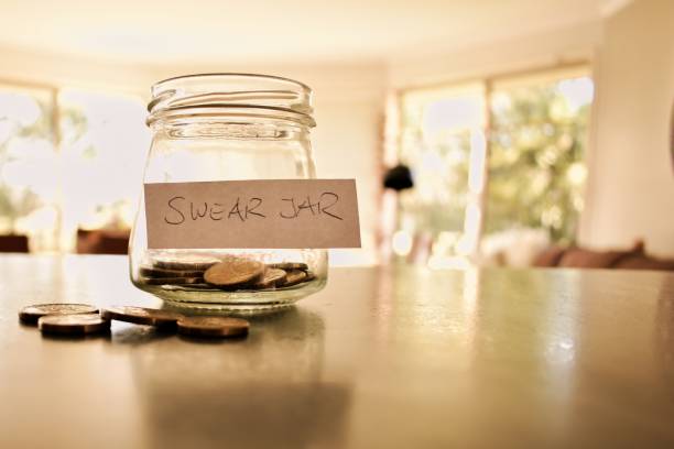 Swear jar filled with coins stock photo