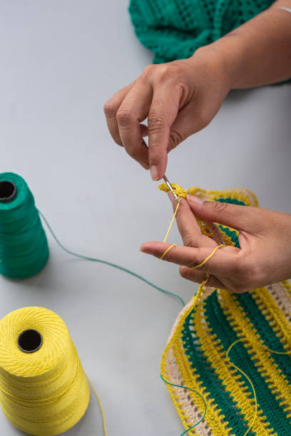istock Woman crocheting pattern with crochet hook close-up. 1225909747