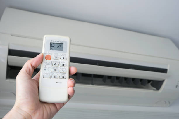 istock Man's hand using remote control open The air conditioner is cooled to 25 degrees Celsius in his bedroom. Health concepts and energy savings 1225918409