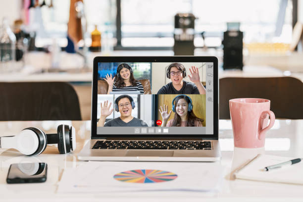 istock laptop with headphone, coffee cup, mobile phone and data graph document showing Asian Business people say hello with teamwork colleague in video conference 1225922844