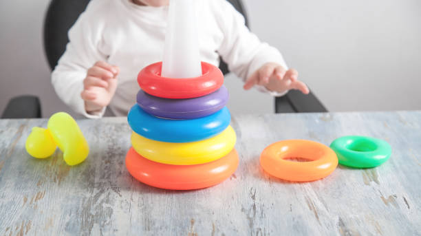 istock Little girl playing with colorful pyramid. 1225924817