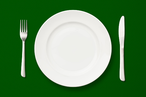 Overhead shot of place setting on green tablecloth.