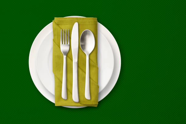 coloque el ajuste en un mantel verde con espacio de copia. - spoon napkin silverware white fotografías e imágenes de stock