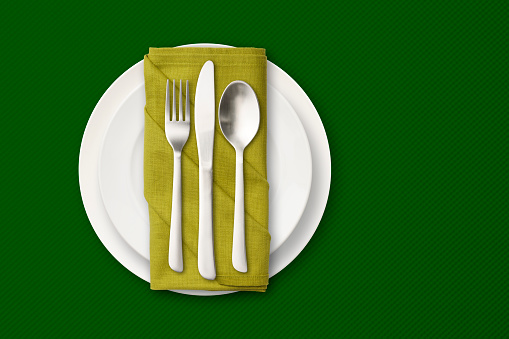 Overhead shot of place setting on green tablecloth with copy space.