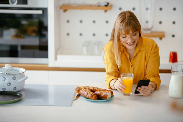 istock Beautiful woman drinking orange juice in the kitchen 1225926820