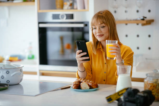 istock Beautiful woman drinking orange juice in the kitchen 1225926836