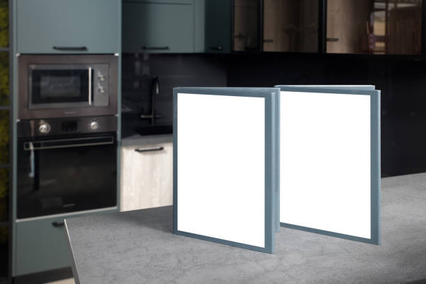 istock Blank mockup book brochure catalog on stoneware countertop with advertising copyspace over out of focus upscale Aqua Menthe kitchen in luxury home with breakfast bar counter wooden panels design. 1225927450