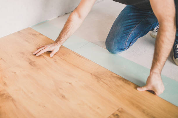 istock Adult man lays the laminate panel on the substrate 1225927567