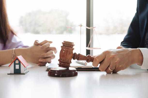 Real Estate Law concept. Gavel on sounding block in hand's Male judge at a courtroom, working for the insurance compensations. report the case on table in modern office. stock photo