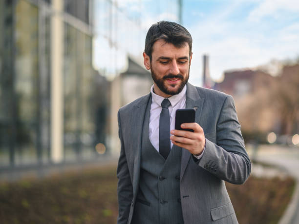 istock Businessman using smart phone and walking down the street 1225930856