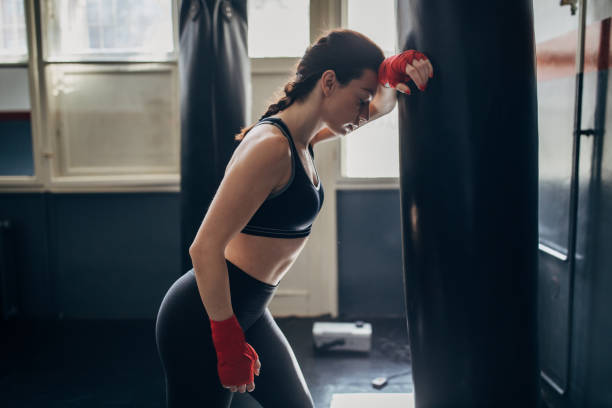 istock Beautiful female boxer standing alone in gym 1225934787