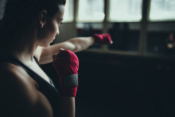 istock Female boxer standing alone in gym 1225935100