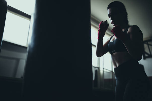 istock Female boxer standing alone in gym 1225935134