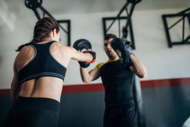 istock Female boxer training with her male coach in gym 1225935904