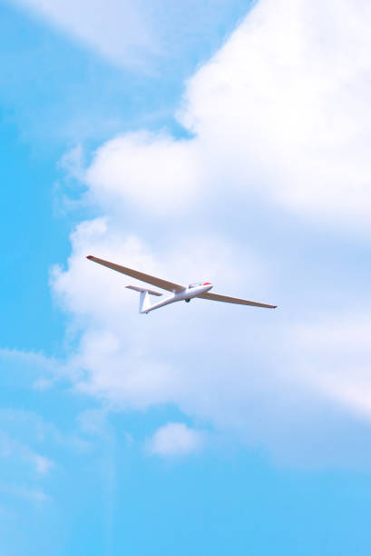 istock Small glider flying against the blue sky and clouds 1225936092