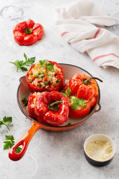 istock Red bell peppers stuffed with rice and vegetables on cast iron pan on gray concret background. 1225937056