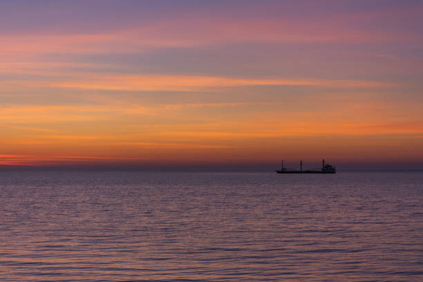 istock Bright twilight sunset sky over the sea. A ship on the horizon. 1225938797