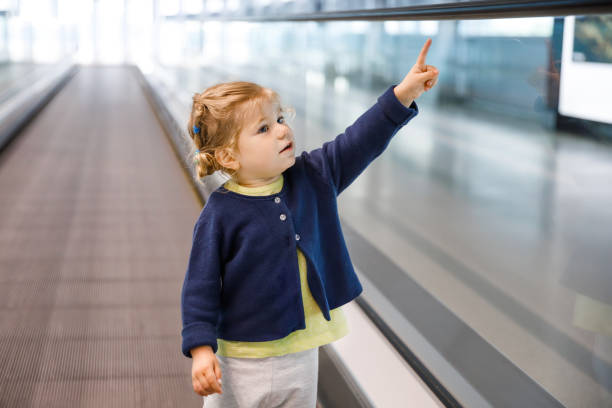 adorável garotinha no aeroporto. adorável criança caminhando até o portão e saindo de férias em família de avião. criança feliz positiva. - escalator child shopping mall little girls - fotografias e filmes do acervo