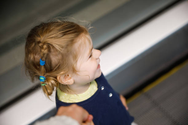 adorável garotinha no aeroporto. adorável criança caminhando até o portão e saindo de férias em família de avião. criança feliz positiva. - escalator child shopping mall little girls - fotografias e filmes do acervo