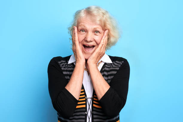 istock excited surprised old lady touching her cheeks, looking at the camera 1225953958