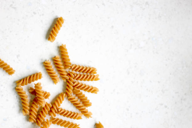 istock Uncooked whole wheat pasta on white background 1225955008
