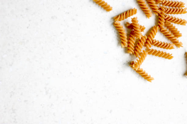 istock Uncooked whole wheat pasta on white background 1225955028