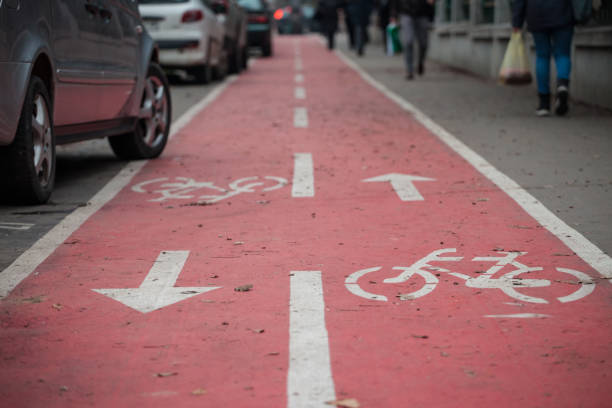 Picture of a car parked half on a bicycle lane, specifically design for bikes, with its iconic standard european logo.