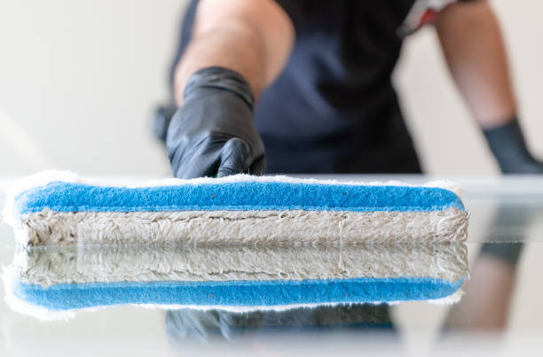 istock professional window cleaner using a window cleaning washer sleeve to cleanse a large fold down apartment window 1225957114