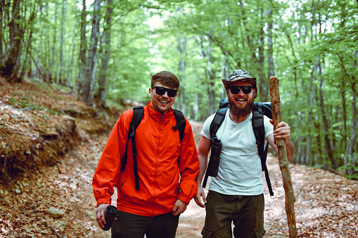 Two Smiling Male Hikers Enjoying Nature's Beauties In Forest