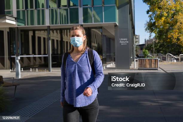 Student Wearing Mask Leaving Library Building Stock Photo - Download Image Now - University, Coronavirus, Protective Face Mask