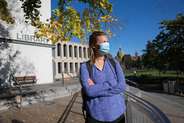 istock Young Woman Wearing Face Mask Waiting Outside Library 1225961930