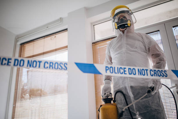 istock Man in protective suit disinfecting and spraying coronavirus infected room building 1225963352