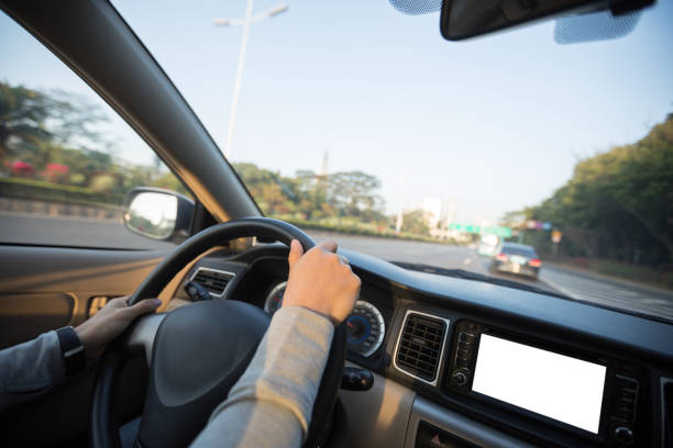 istock People hands holding steering wheel while driving car on city road 1225963618