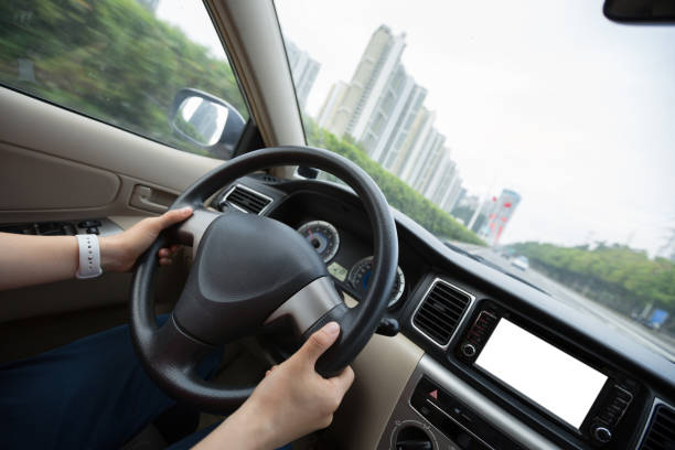 istock People hands holding steering wheel while driving car on city road 1225966623