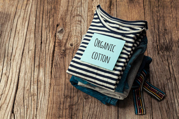 istock Stack of organic clothes on a wooden background. Natural eco-friendly fabric 1225968203