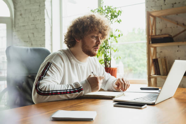istock Manager or student working from home while being insulated or keep quarantine 'cause of coronavirus COVID-19. Making notes. 1225968629