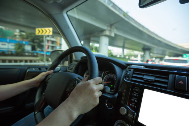 istock People hands holding steering wheel while driving car on city road 1225971050