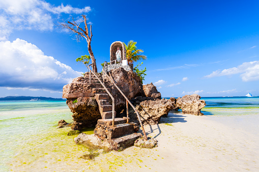 Willys Rock is a tidal island with a statue of the Virgin Mary at the Boracay beach in Philippines