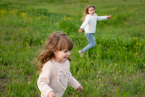 istock sisters play in the park at sunset 1225974137
