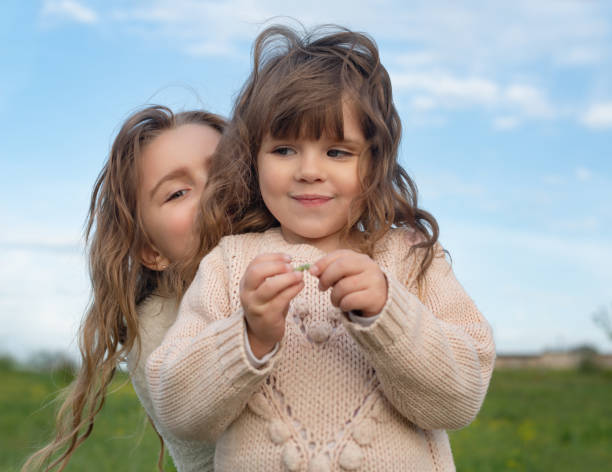istock sisters play in the park at sunset 1225974466