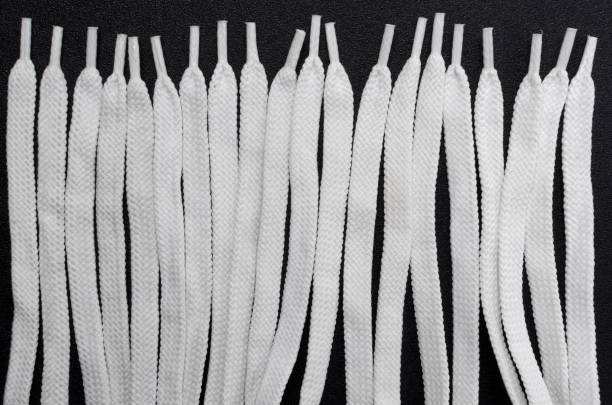 istock Top view of rows of white laces as a background, black surface 1225977406