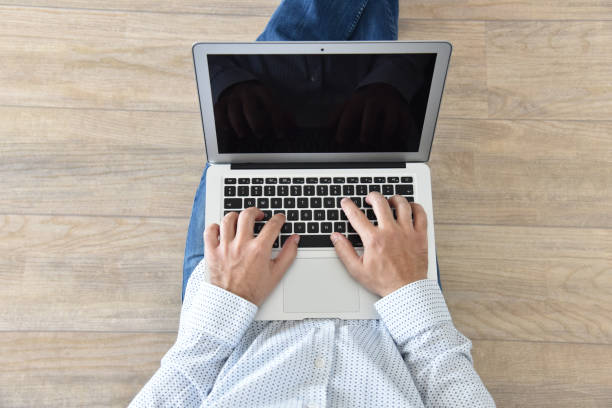 istock A man holds a laptop on his lap. 1225980339