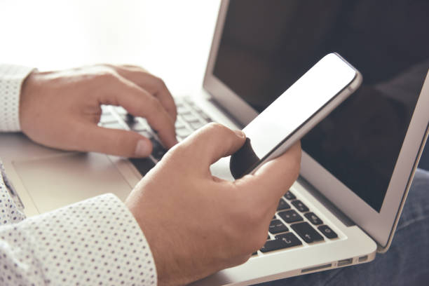 istock Business communication. Man using smartphone and laptop. 1225980373